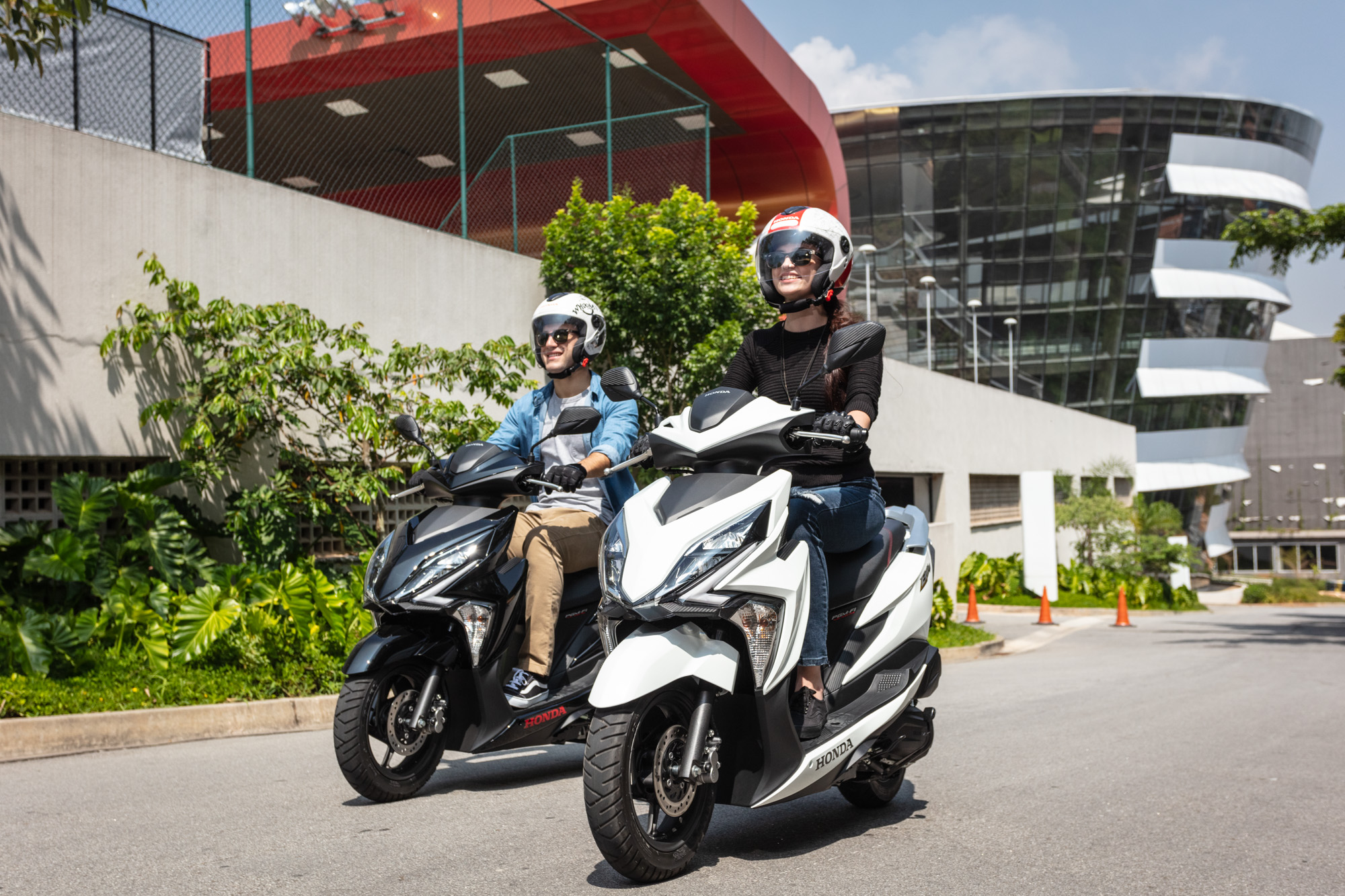 Homem e mulher sorrindo em moto Honda Elite 125