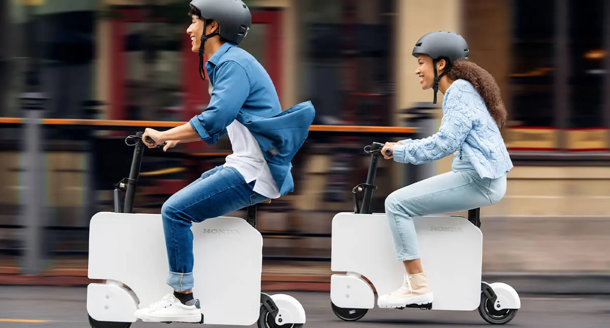 Um Homem e Uma Mulher dirigindo a nova Honda Motocompacto 