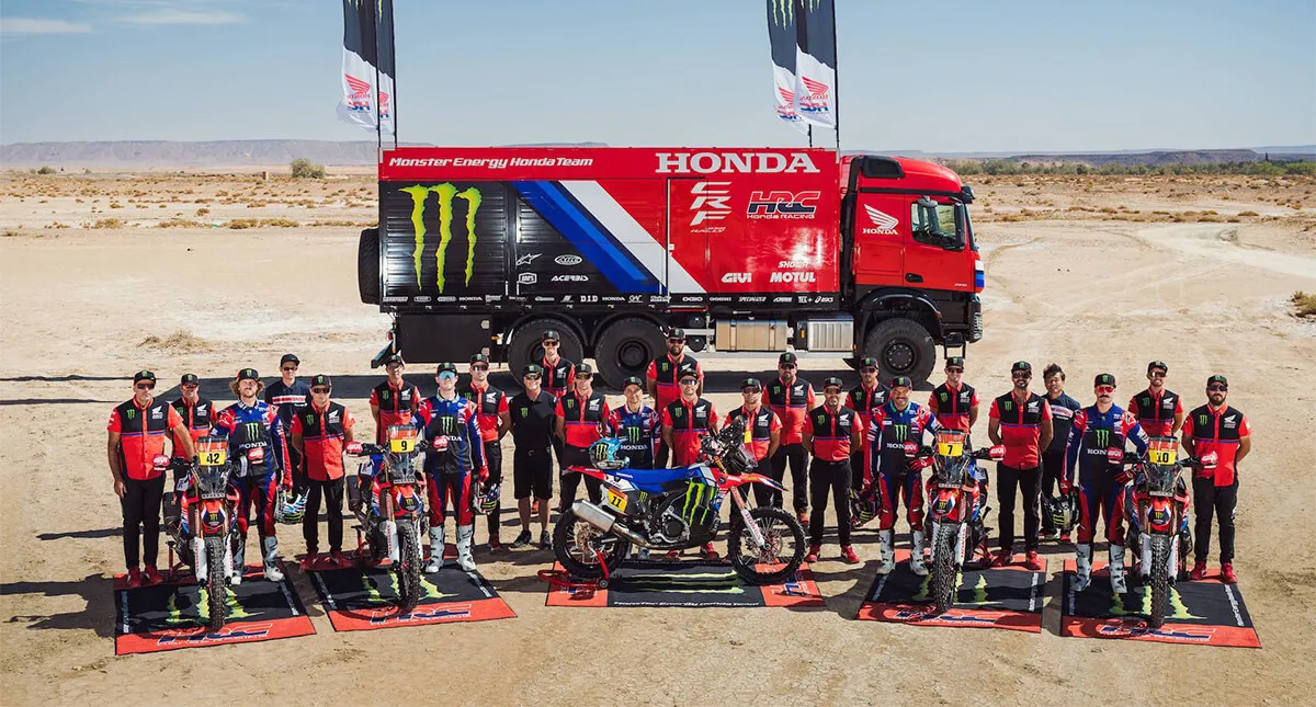 Equipe Honda Racing à frente de um caminhão e com motocicletas à frente  do time