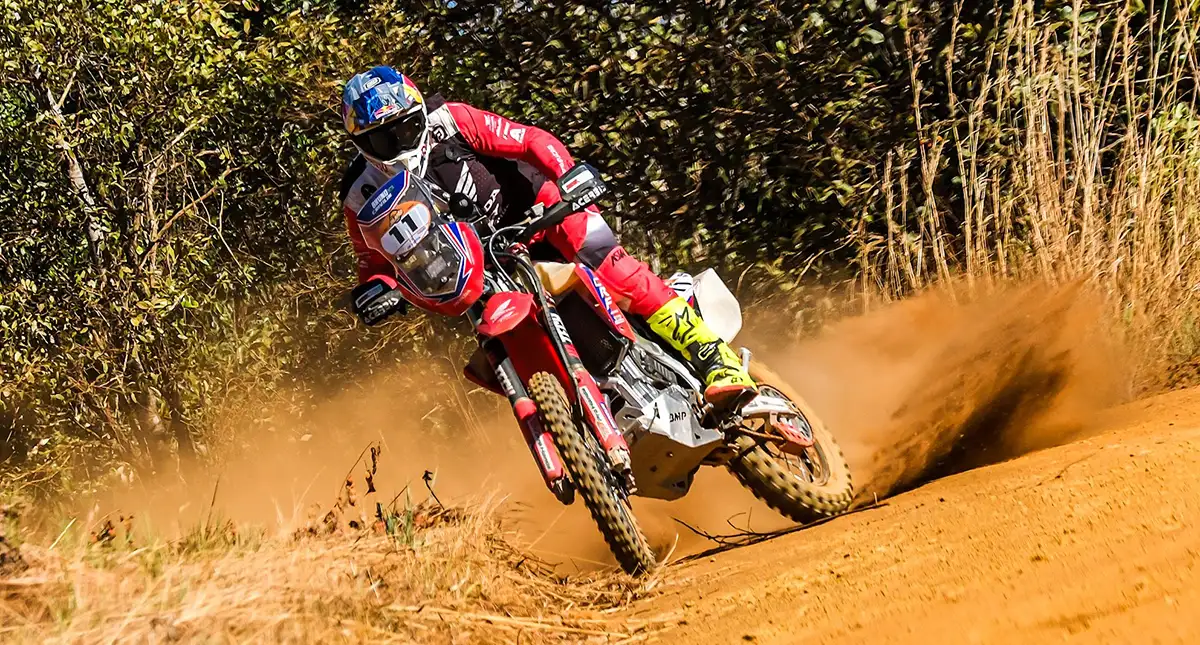 motociclista praticando off-road em uma trilha de terra