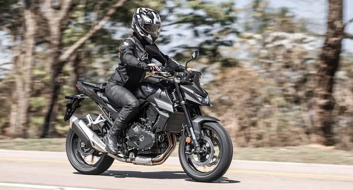 Mulher pilotando Honda CB750 Hornet em movimento